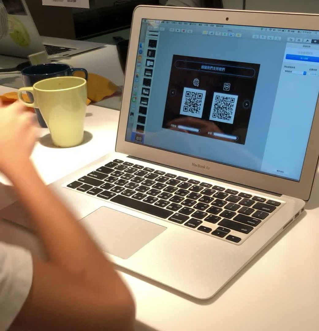 四個孩子做出來的電商網站首頁，畫面上是「掃描我們支持我們」與兩個 QR code。