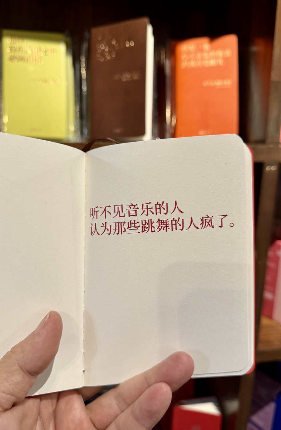 青島良友書坊拍的筆記本,紅字寫著「聽不見音樂的人,認為那些跳舞的人瘋了。」