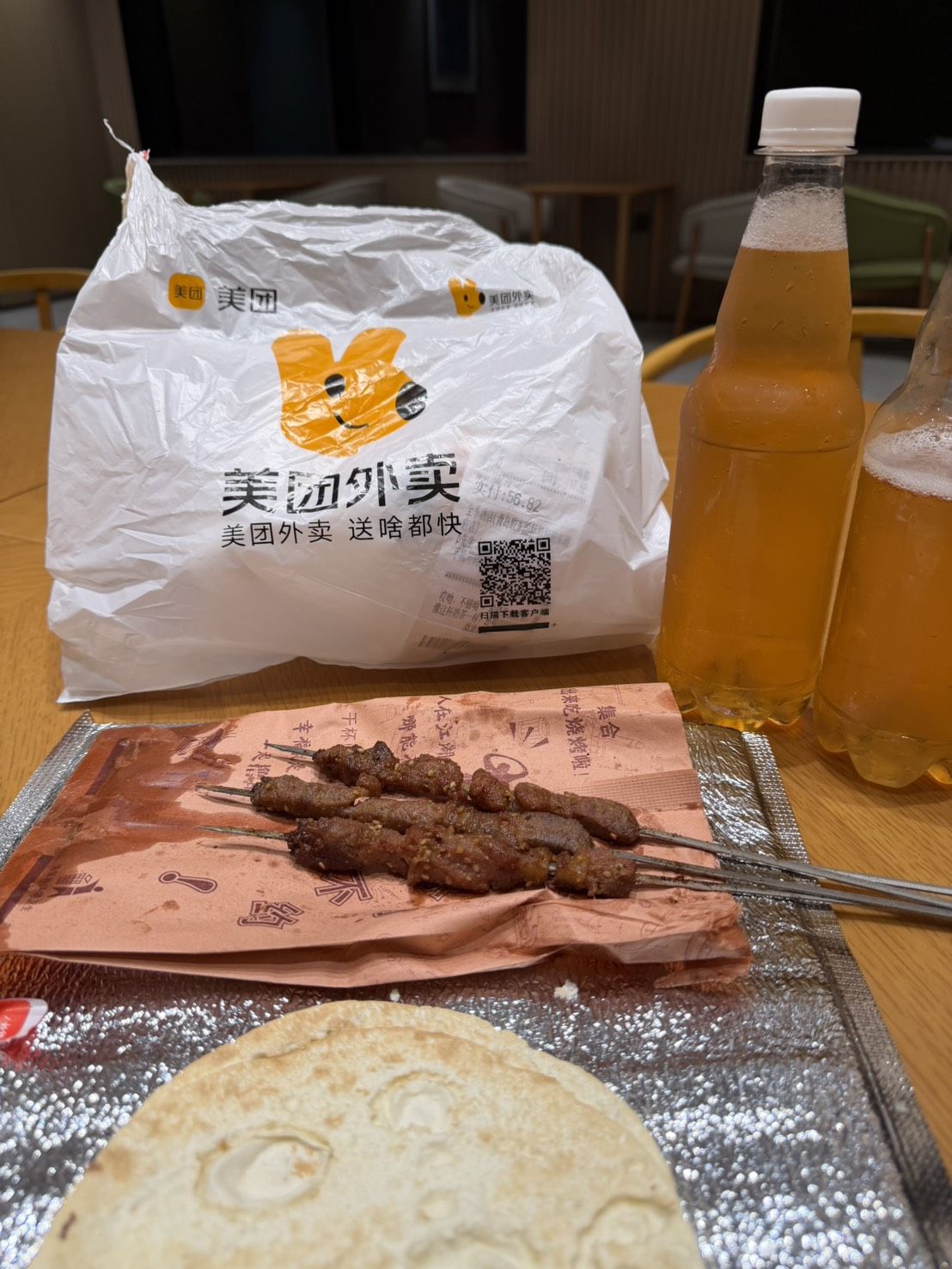 凌晨一點,美團外賣送來的烤串、餅與兩瓶當日鮮釀啤酒,攤在飯店大廳的桌上